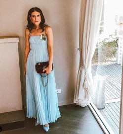 Woman in a flowy blue wedding guest dress.
