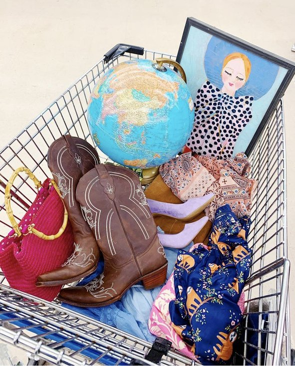 Shopping cart full of thrifted items.