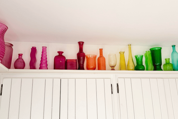 Rainbow vases on a shelf.